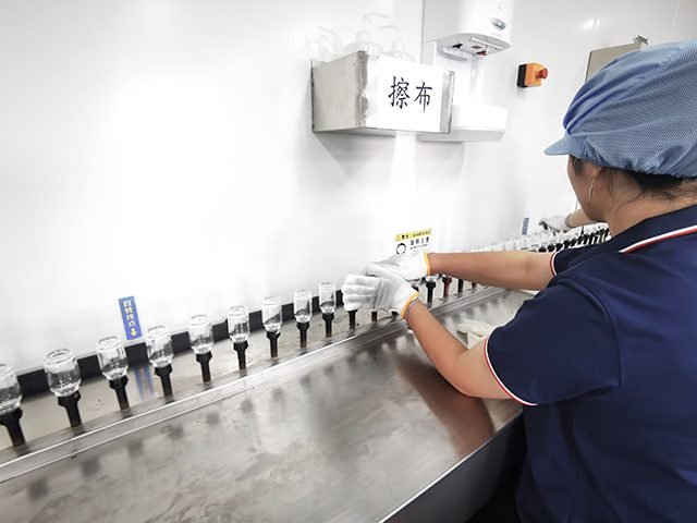 Operator inspecting bottles by hand