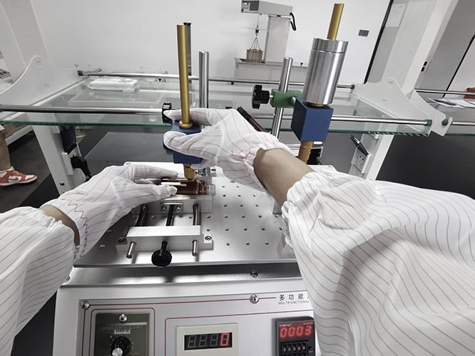 Technician testing a component on a precision tester